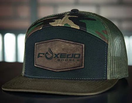 a hat with a brown patch on it flat brim camo design