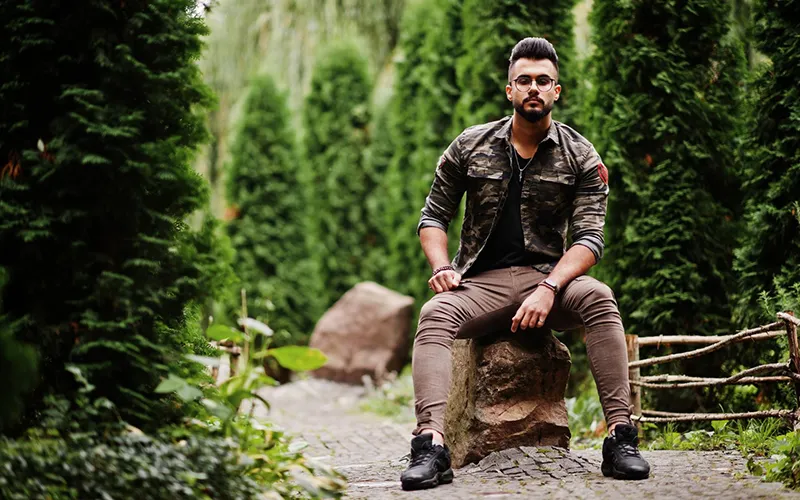 camo jacket wearing in jungle and green trees