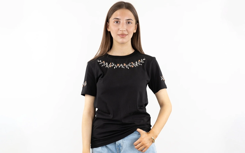 Women wearing black color Embroidered T-shirt on which white and brown Embroidered flowers