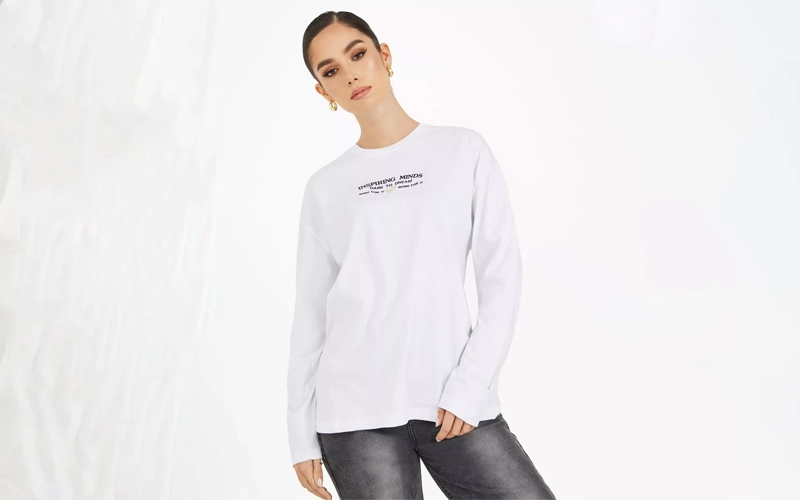 women wearing white color Long-line T-shirt with some text printed on it.