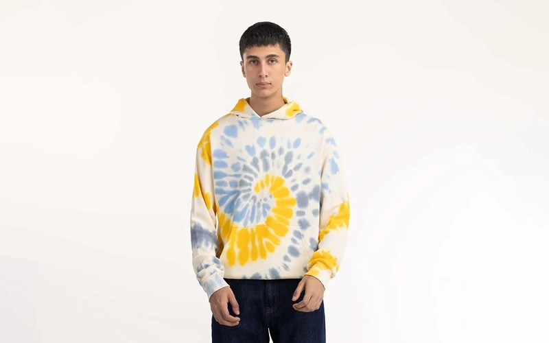 A man wearing yellow and grey tie-dye hoodie