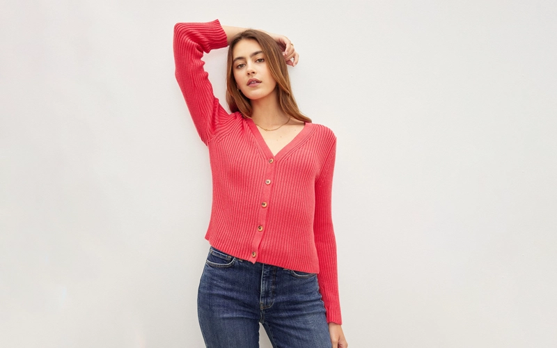 A women wearing a pink color button front Cardigans.