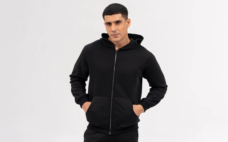 A man wearing black zip up hoodie