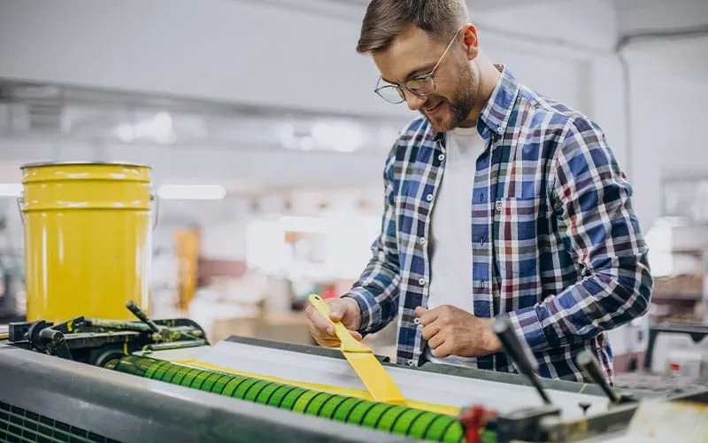 A dye-sublimation printer working on transferring vibrant, full-color graphics onto fabric, ideal for promotional items, sportswear, and customized clothing.