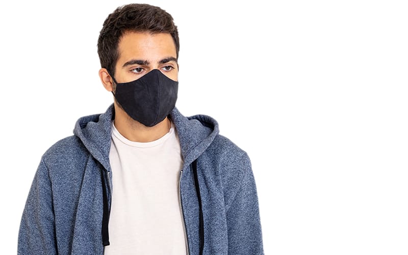 A man wearing a vintage wash blue hoodie and a black mask, standing with a neutral expression against a white background.