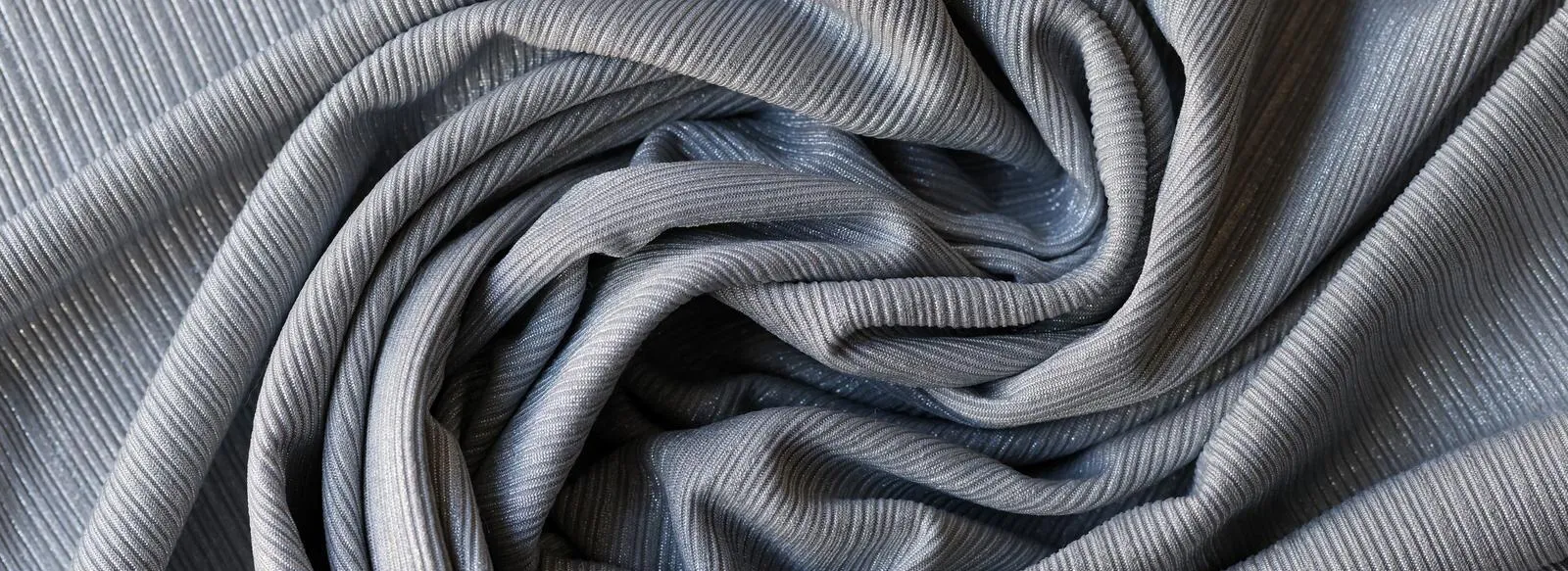 A smooth and elegant gray acrylic fabric with a subtle texture, rolled up for a professional display.