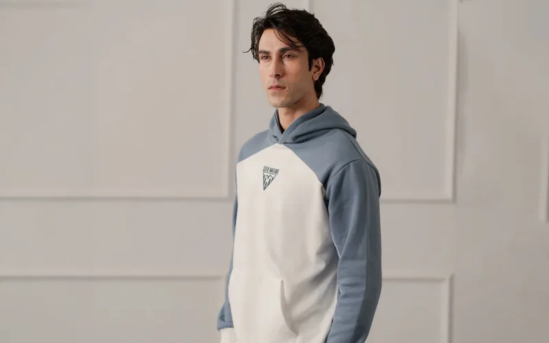 Men's two-tone pullover hoodie in white and blue with a graphic logo on the chest